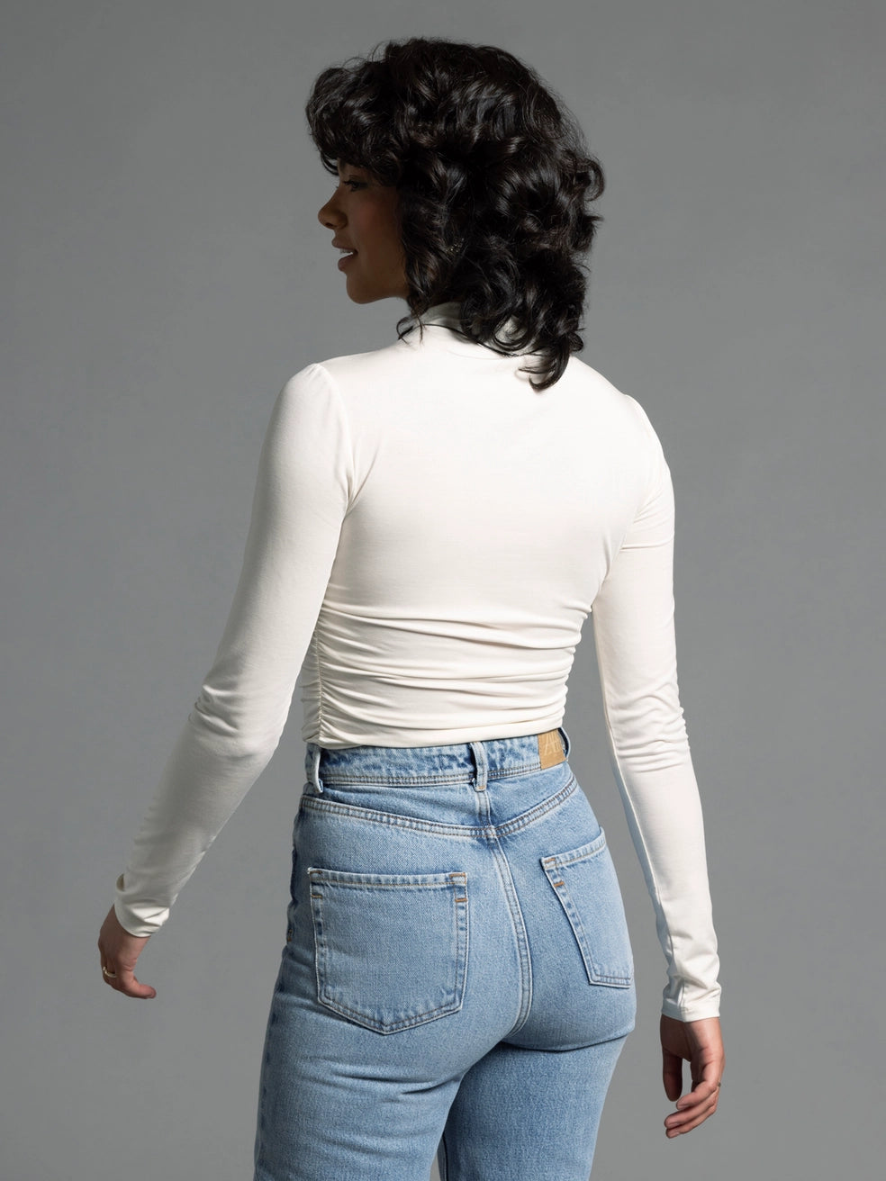 Back view of cream ruched top showing smooth seam lines and fitted design.