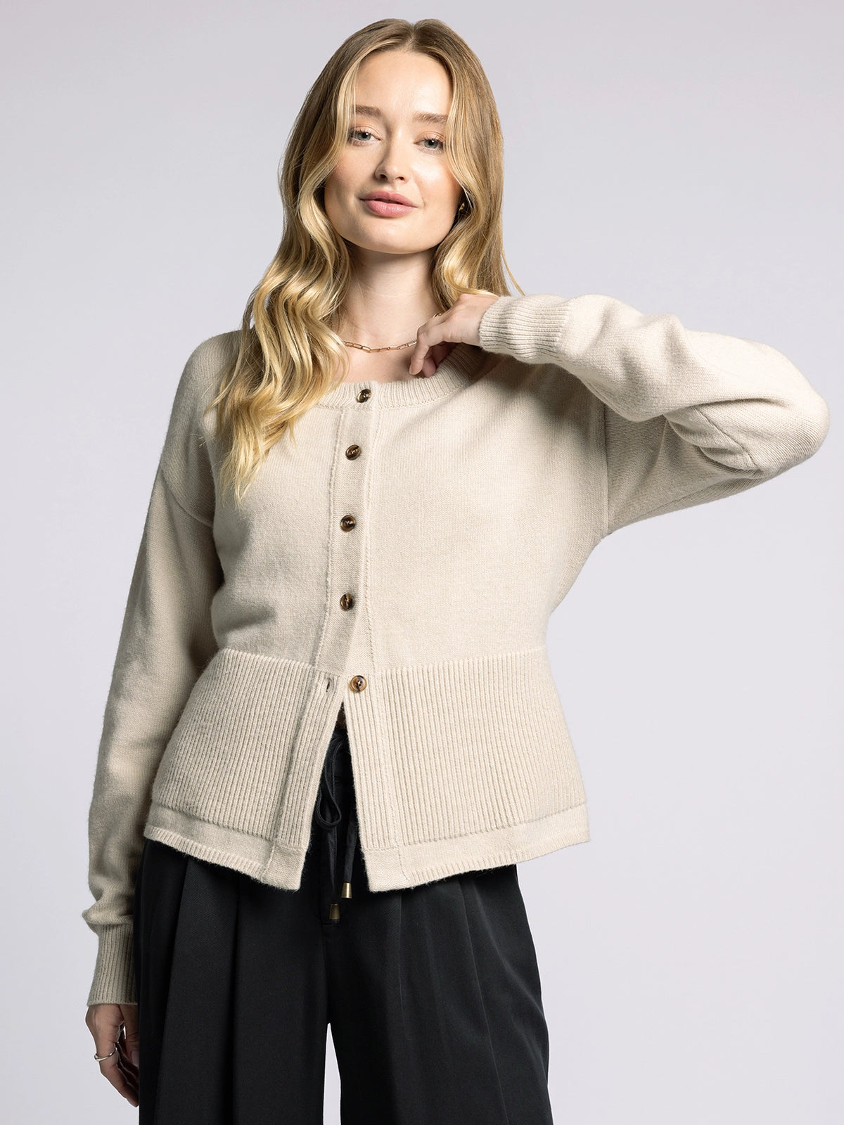 Model wearing the Michelle Cardigan by The Weekend LA in soft beige with button-front closure and relaxed fit.