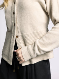 Close-up detail of Michelle Cardigan by The Weekend LA showing ribbed hem, button closure, and peplum knit texture.