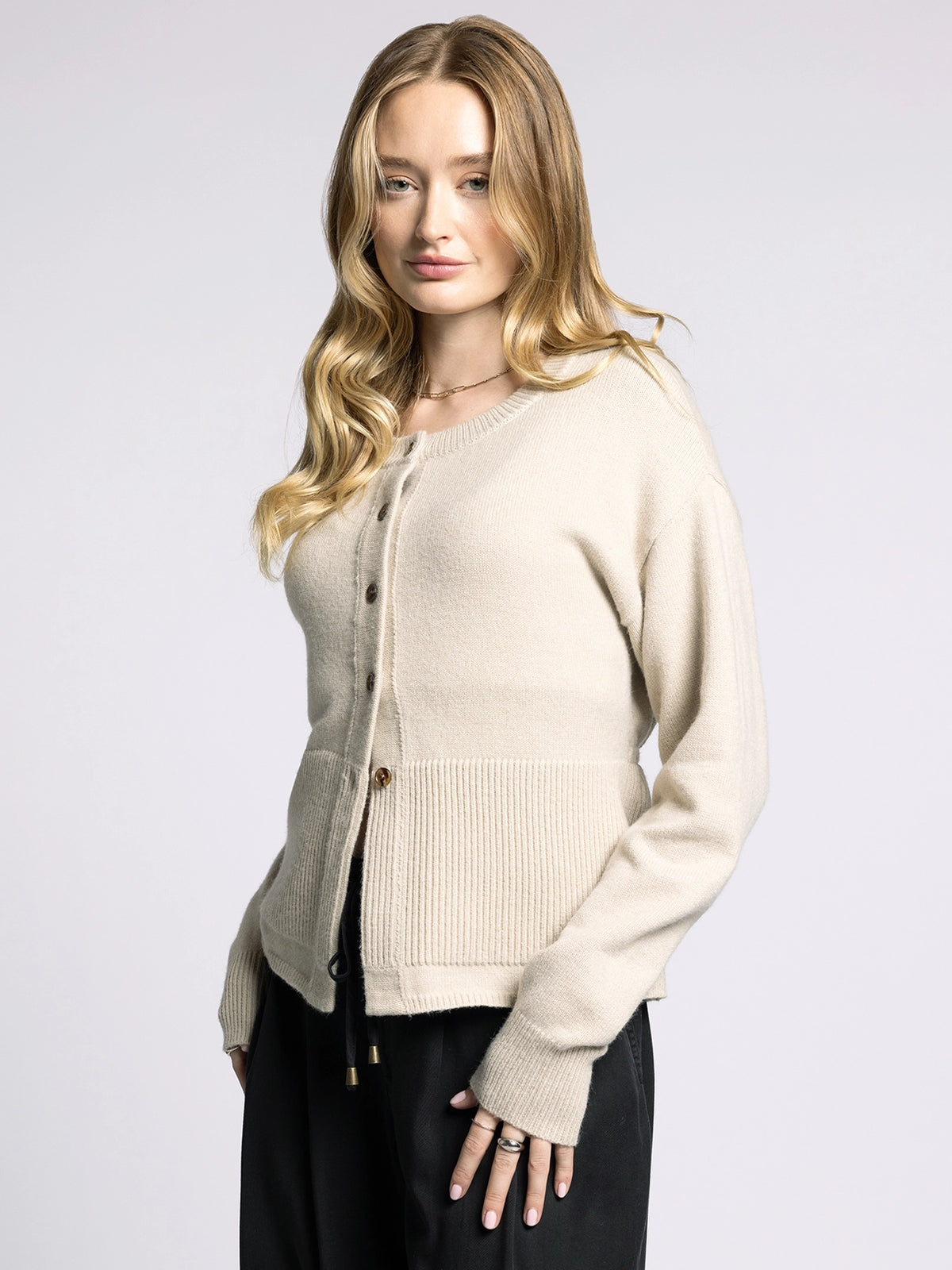 Side profile of Michelle Cardigan highlighting drop shoulder design and fitted peplum waist.