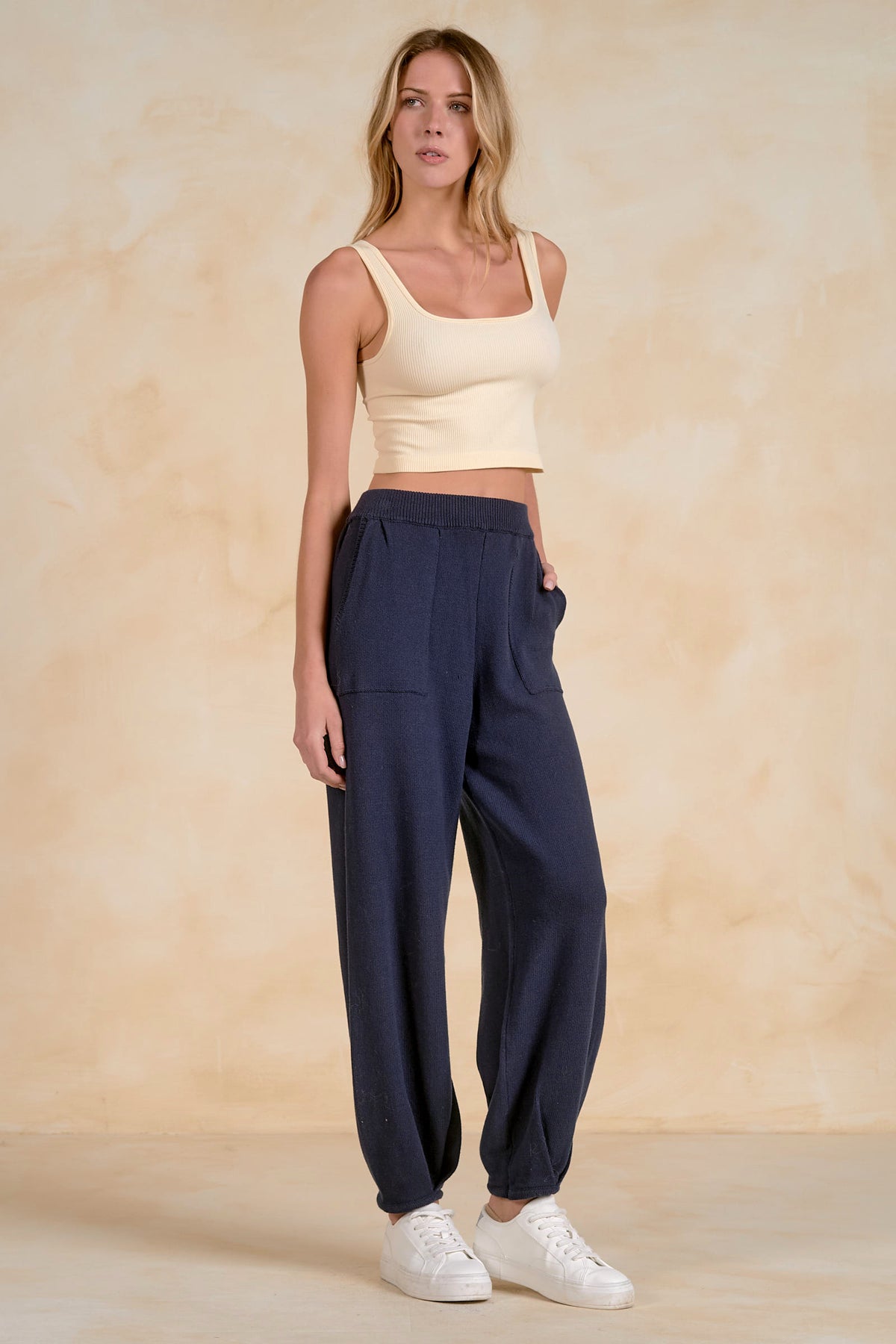 Side view of Blaine navy knit pants showing ribbed waistband, knit texture and front pockets