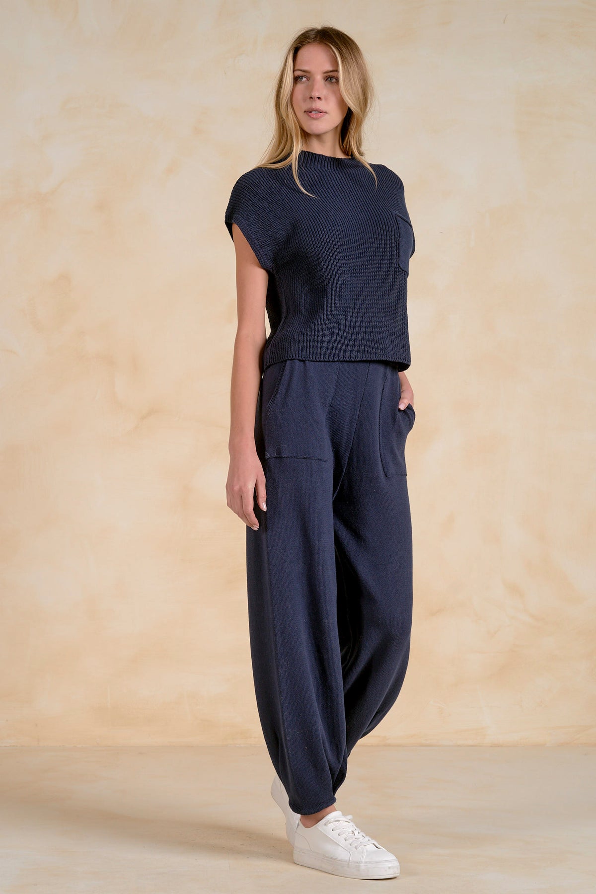 Side view navy short sleeve sweater top with chest pocket styled with matching knit pants