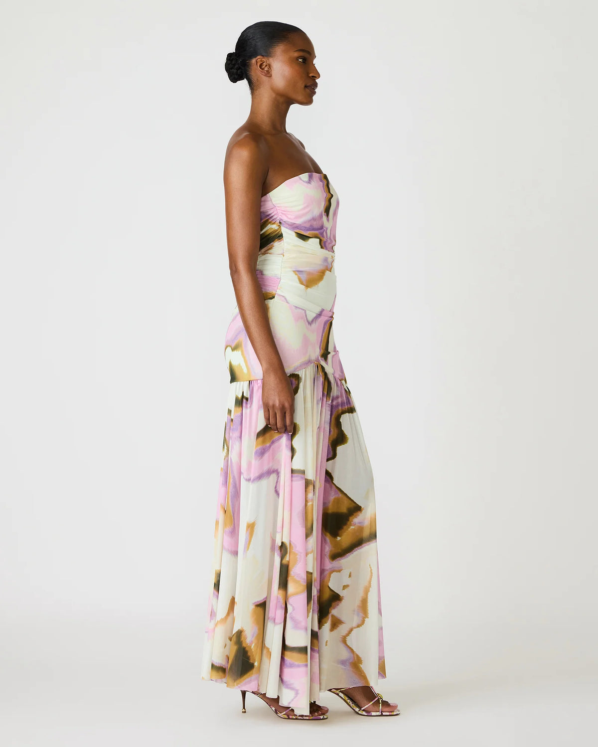 Woman wearing a strapless floral dress on a white background