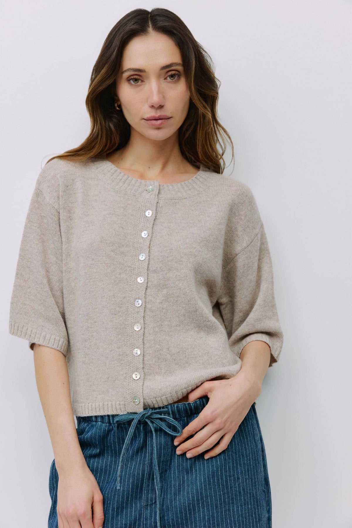 Model wearing beige button-front knit cardigan from Shop Reverie Co.