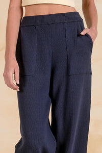 Close-up of Blaine navy knit pants showing ribbed waistband, knit texture and front pockets