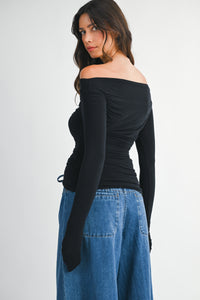 Back view of Charlotte Off-Shoulder Ruched Top highlighting fitted silhouette and lightweight knit material.