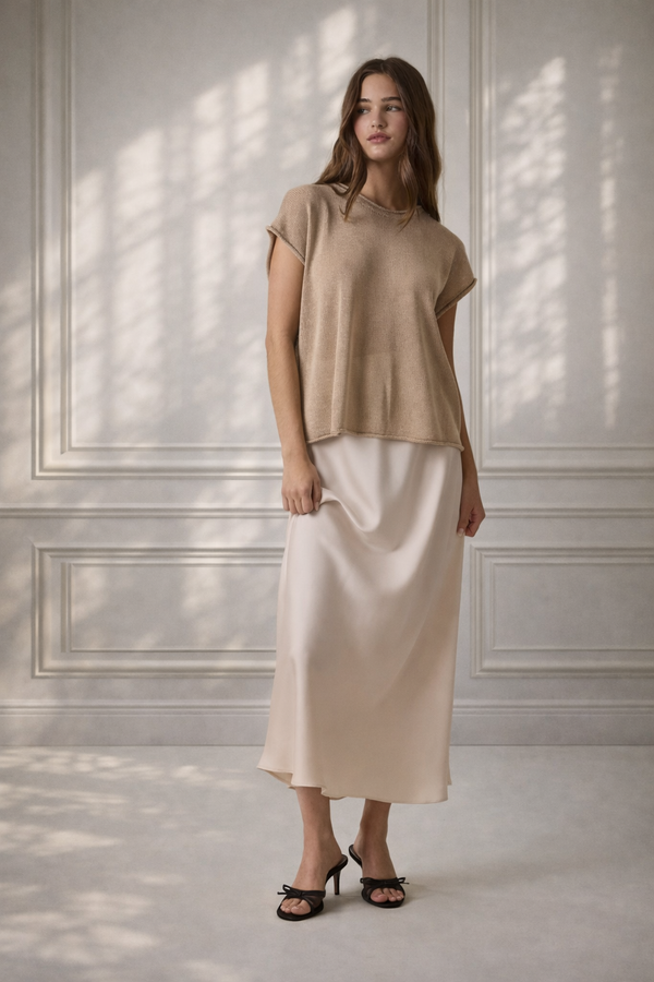 Model wearing elegant cream satin midi skirt styled with neutral top