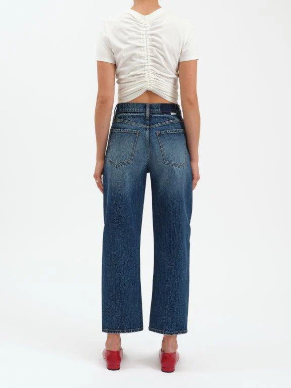 Person wearing blue jeans and a white top on a white background