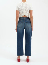 Person wearing blue jeans and a white top on a white background