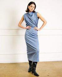 Full outfit featuring blue mock neck draped top styled with black boots.