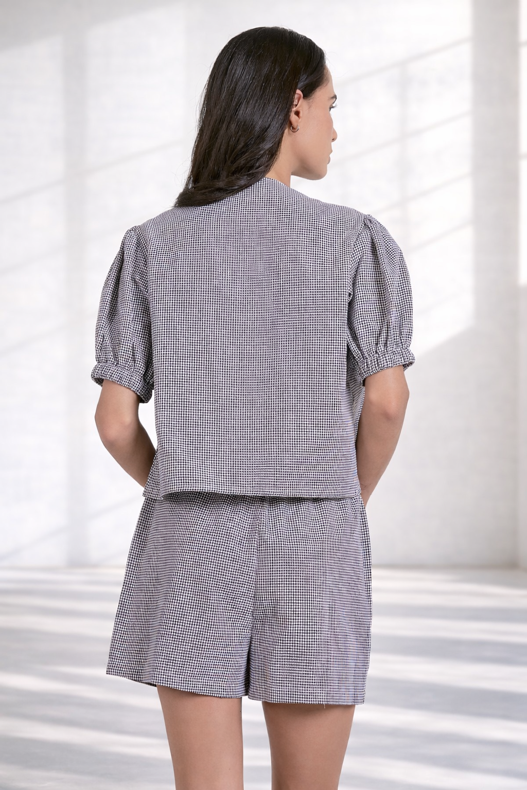 Back view of women's black and white gingham blouse with relaxed fit