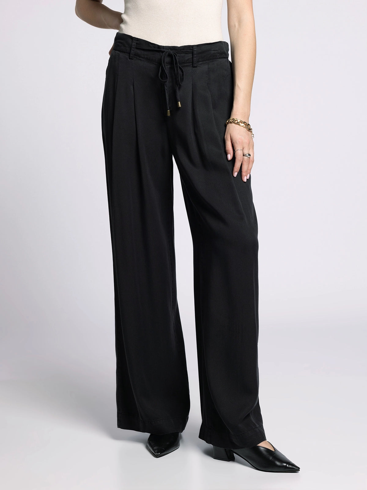 Model wearing Gloria Wide Leg Pants with cream top, showing elastic waistband and relaxed cut.