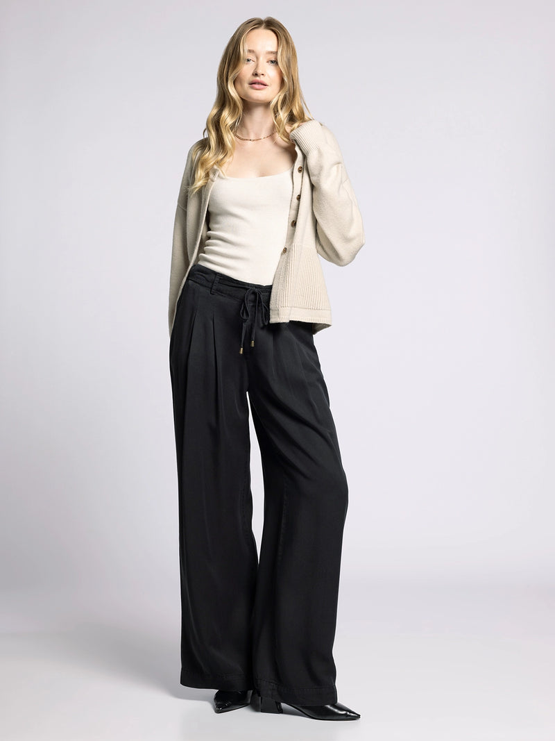 Model wearing Gloria Wide Leg Pants styled with neutral cardigan and tank top for casual chic look.