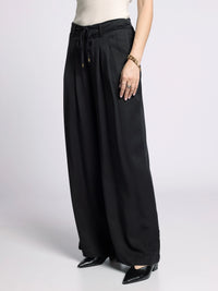 Side profile of Gloria Wide Leg Pants highlighting wide leg silhouette and flowy fabric.