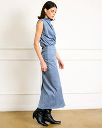 Side view of elegant blue suede midi skirt paired with sleeveless draped top.