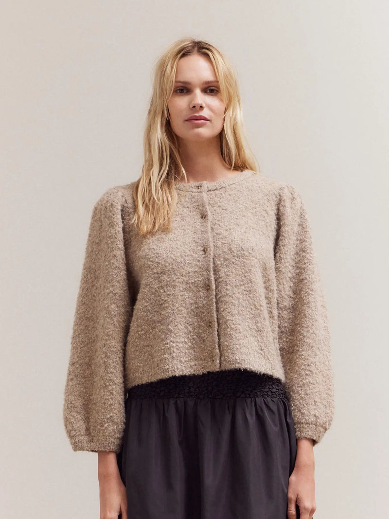 Model wearing the Lacie Cardigan in neutral taupe — textured knit cropped sweater with button front and balloon sleeves from Shop Reverie.