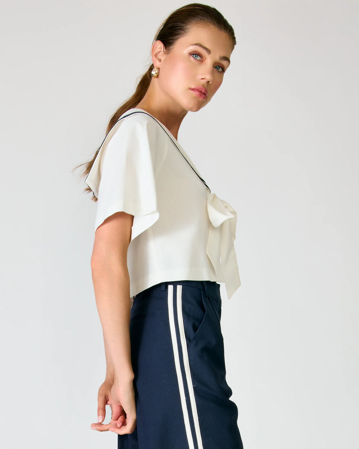 Close-up of the waist area on the Line and Dot Anchor Pants, showing the clean front closure, slant pocket, and how the side stripe meets the waistband.