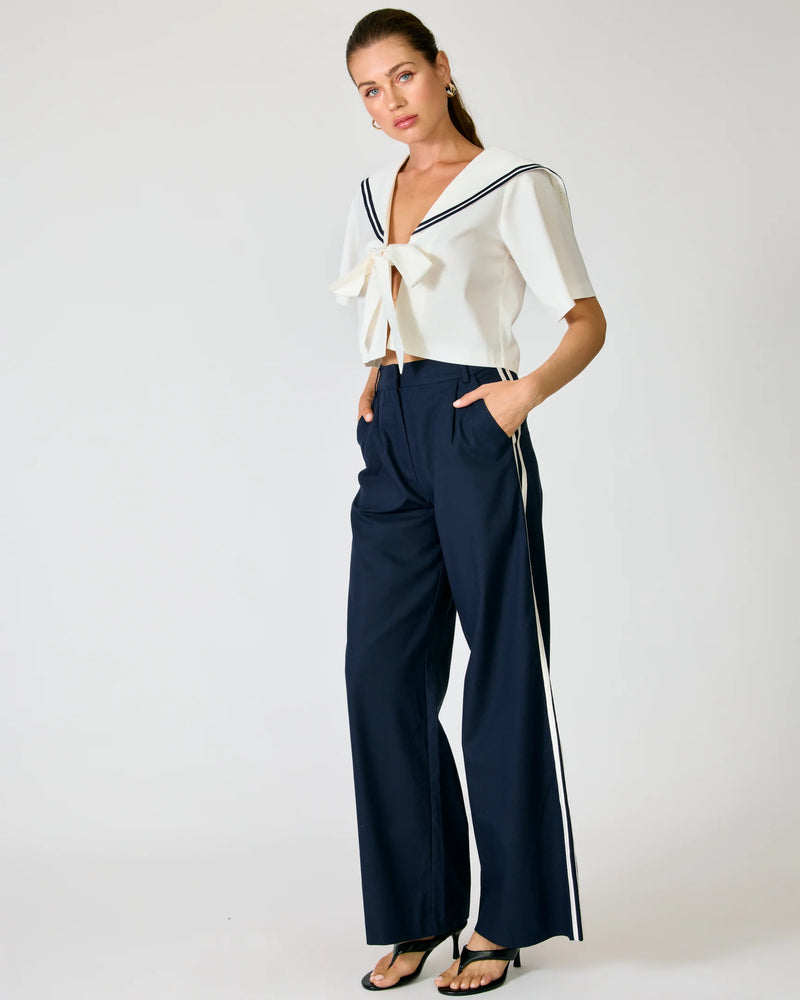 Front angled view of the Line and Dot Anchor Pants, showcasing the navy blue woven fabric, slant hip pockets, and flowing wide-leg fit.
