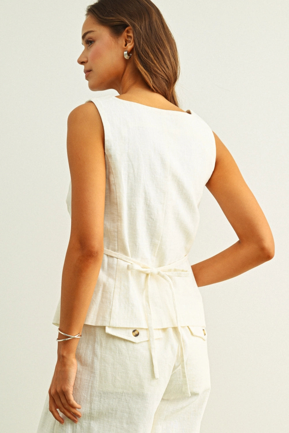 Back view of cream linen vest top with adjustable tie waist detail