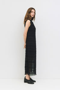 Side view of boutique black sleeveless dress with minimalist silhouette.