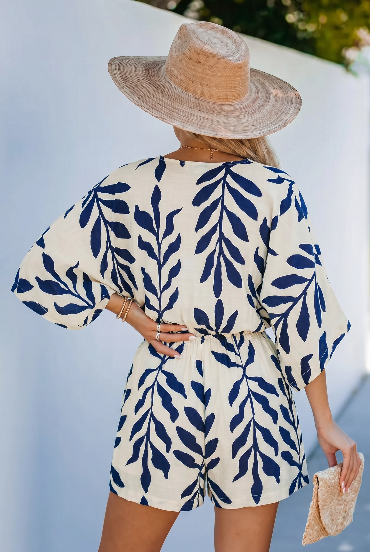 Detailed back view of the navy and white leaf romper showing the elasticized waist tie and relaxed open-back construction.