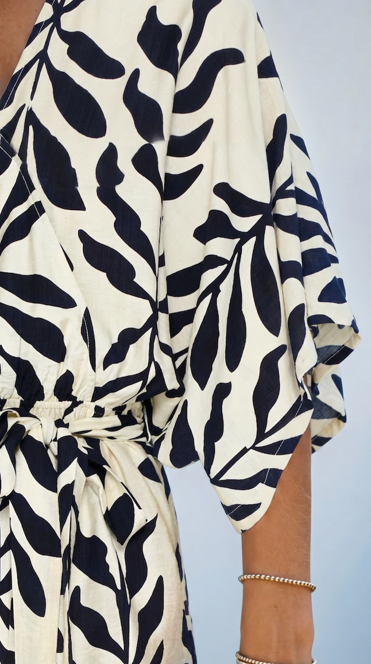 Close-up shot of the crisp navy and white leaf print pattern on the lightweight, breathable fabric of the romper.