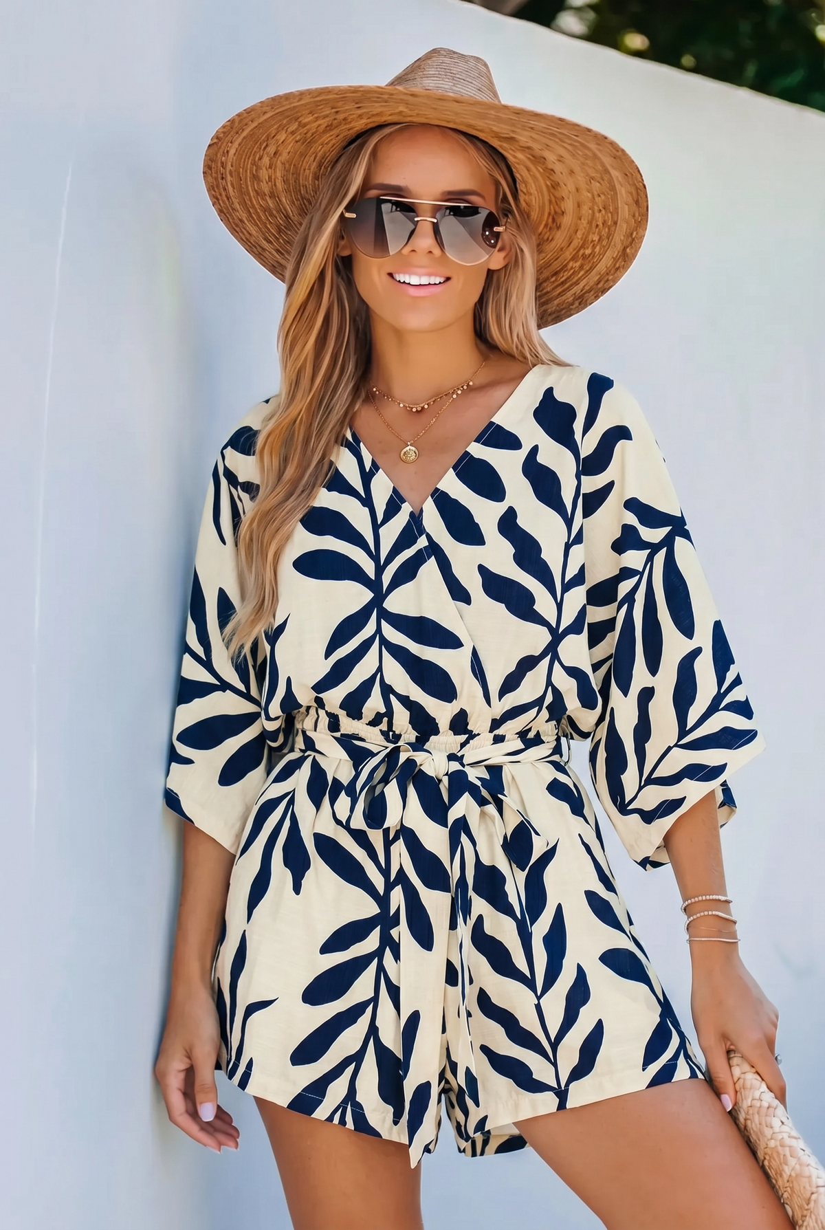 Side profile of a model walking in a navy blue printed romper, demonstrating the flowy kimono sleeves and airy fabric.