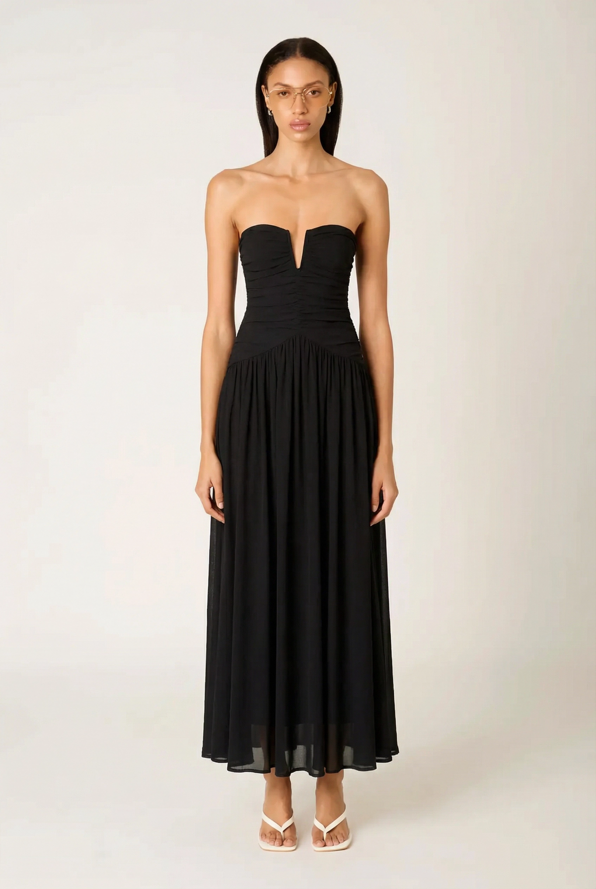 Front view of the NIA Beverly Maxi Dress in black, showcasing the ruched strapless bodice, V-wire sweetheart neckline, and flowing gathered chiffon skirt.