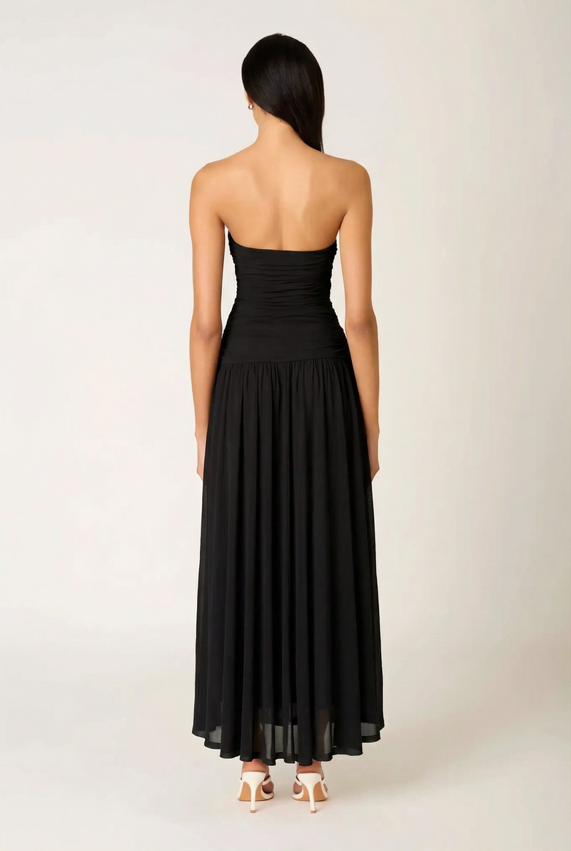 Back view of the NIA Beverly Maxi Dress, displaying the clean strapless back design, hidden side-zip closure area, and floor-sweeping pleated skirt.