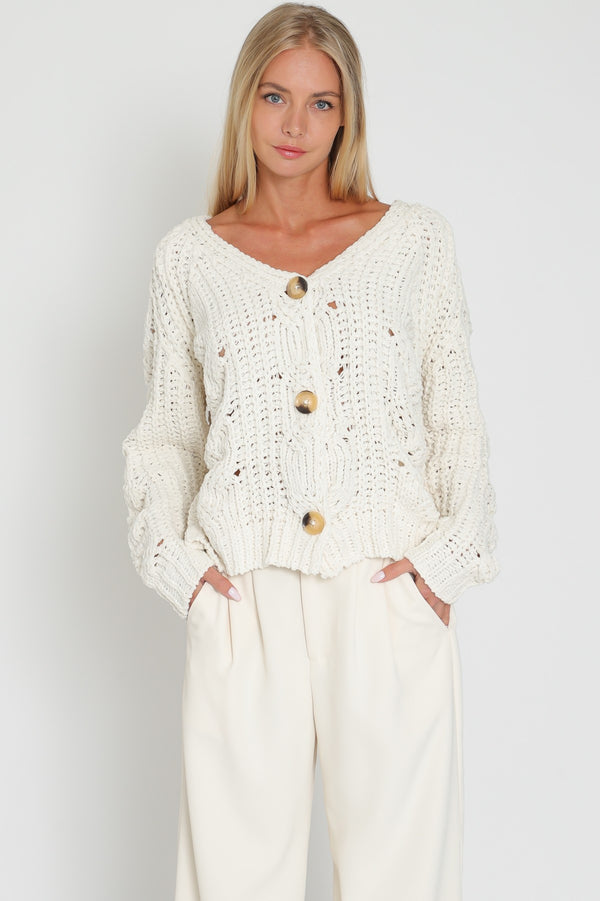 Women in chunky knit button front sweater