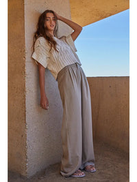 Model wearing Steph Crochet Sweater with wide-leg pants, lightweight open-knit best seller in natural cream.