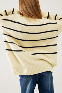 Back view of oversized striped sweater showing side slit and ribbed hem details.