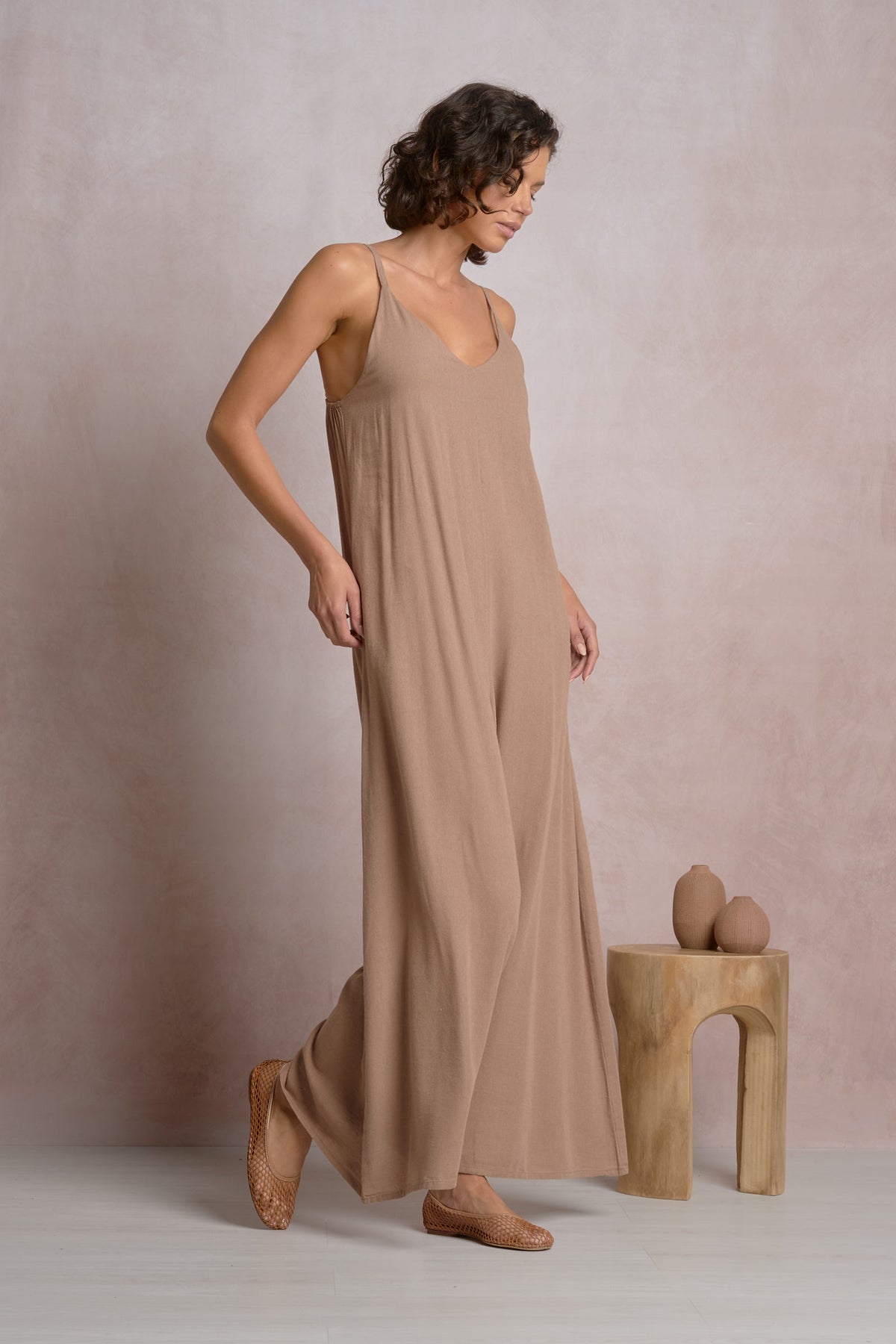Angled front view of the Courtney relaxed fit flowy jumpsuit in brown, highlighting the elegant drape and movement of the wide-leg silhouette.