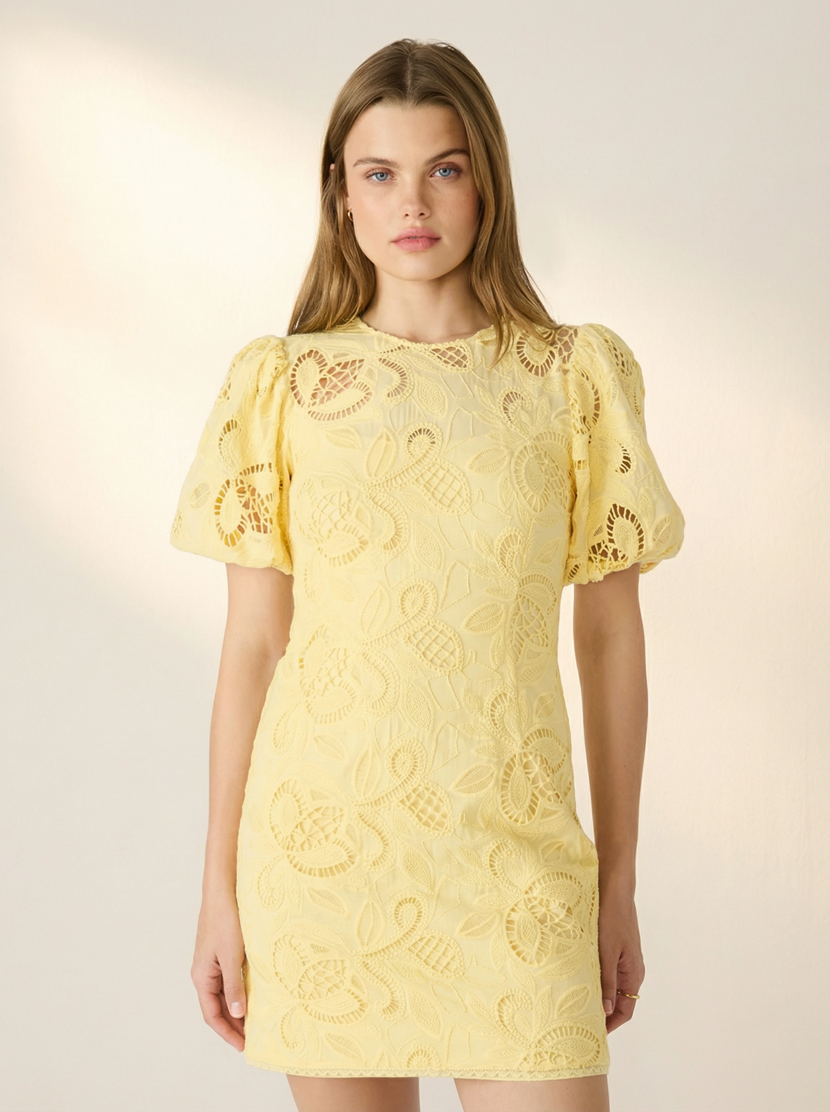 Close-up of the bodice on the Steve Madden Elly creamed corn yellow dress, detailing the round neckline, puff sleeves, and delicate cotton eyelet lace pattern.