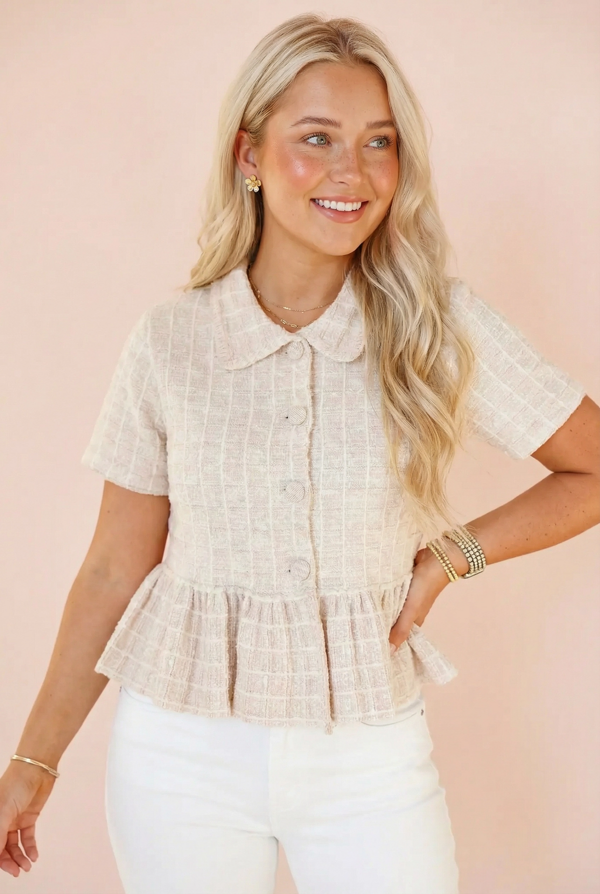 Model wearing the Steve Madden Roxanna cream tweed peplum top with short sleeves and a spread collar, styled with white pants.