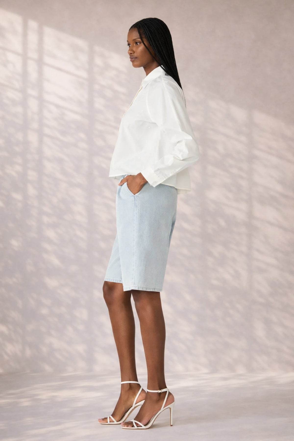 Side profile of Steve Madden Tess Button Front Shirt styled with light wash denim shorts