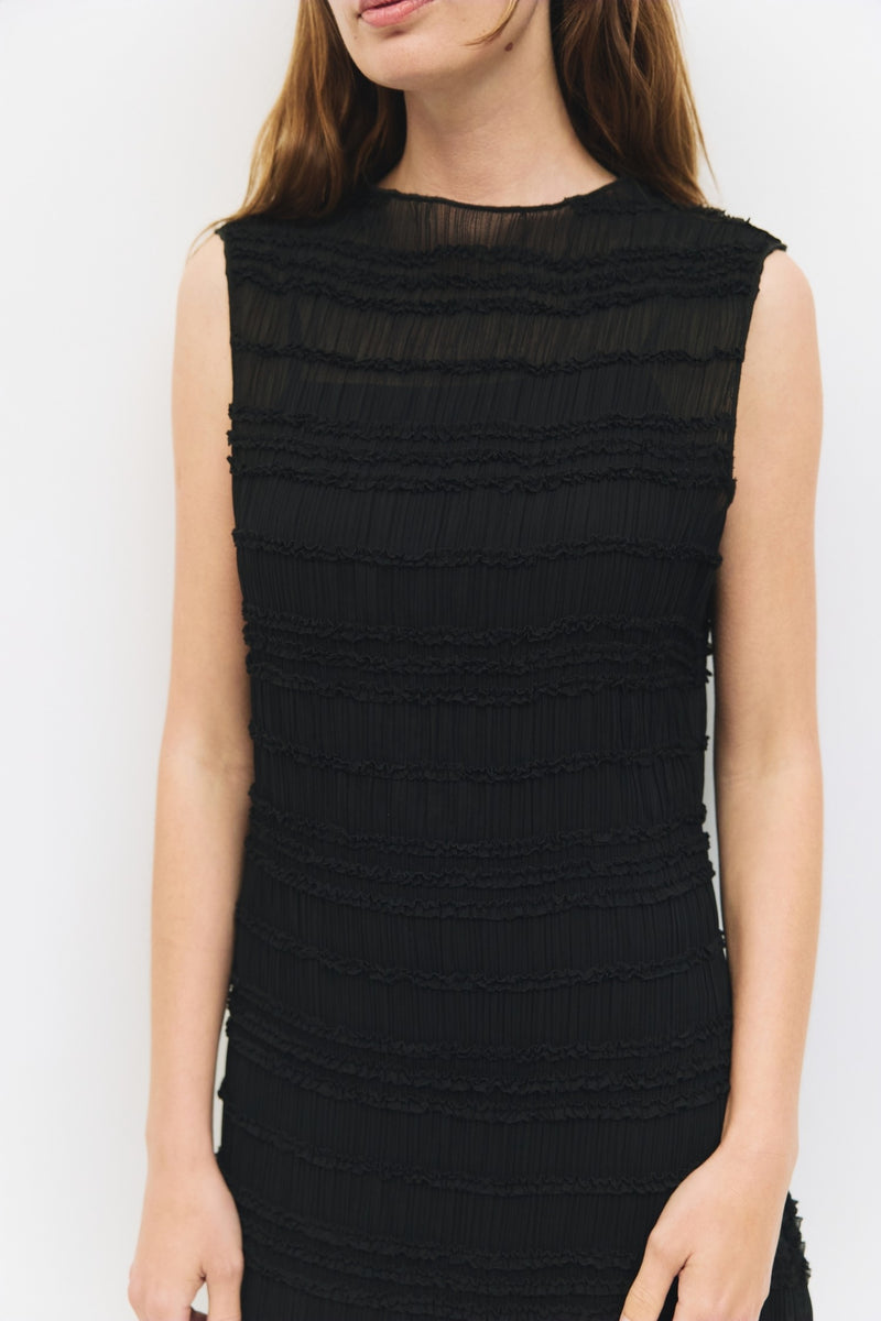 Close-up of textured fabric detail on black sleeveless maxi dress.