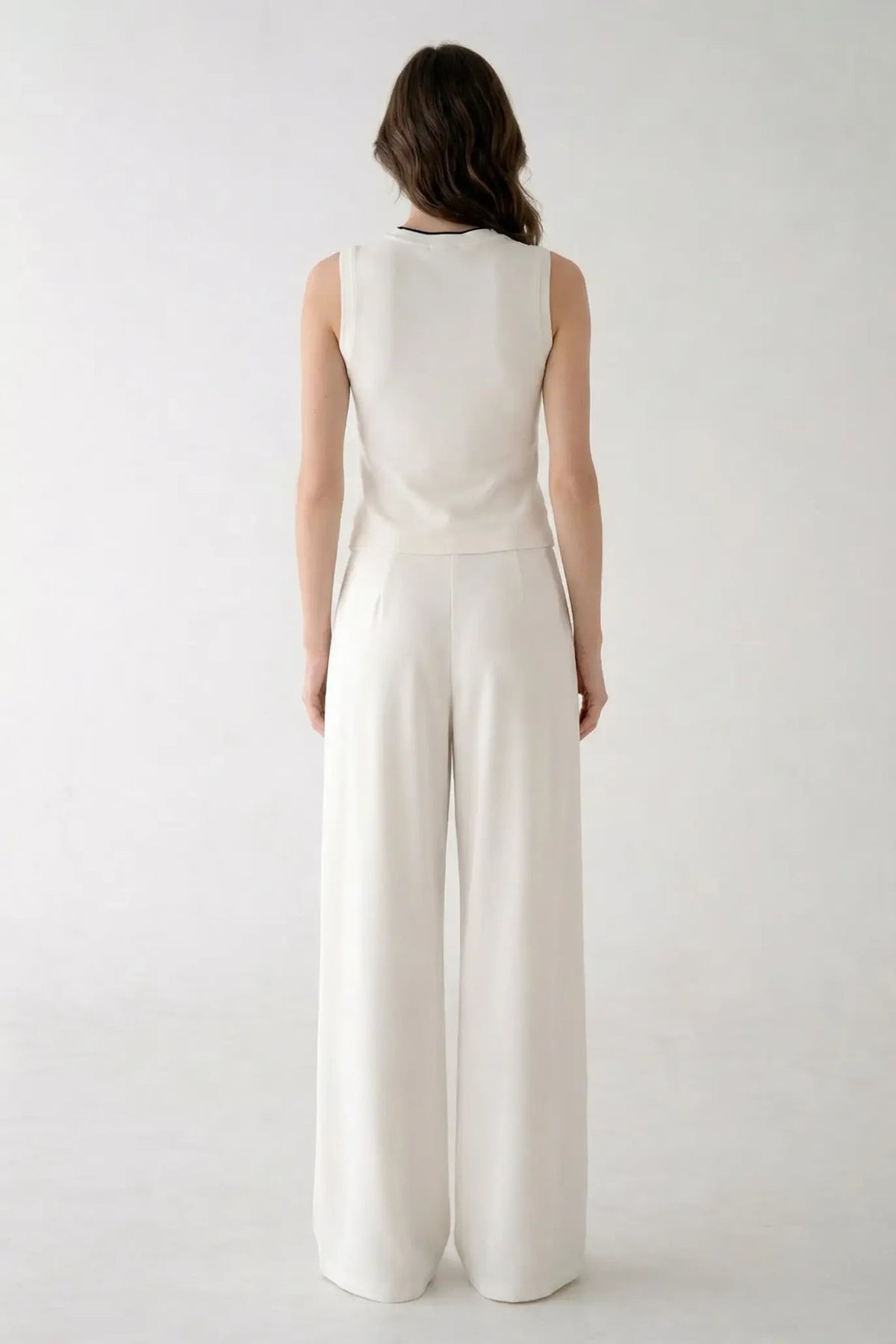 Back view of women's white high-waisted wide-leg sweatpants, demonstrating the smooth fit and floor-length palazzo silhouette.